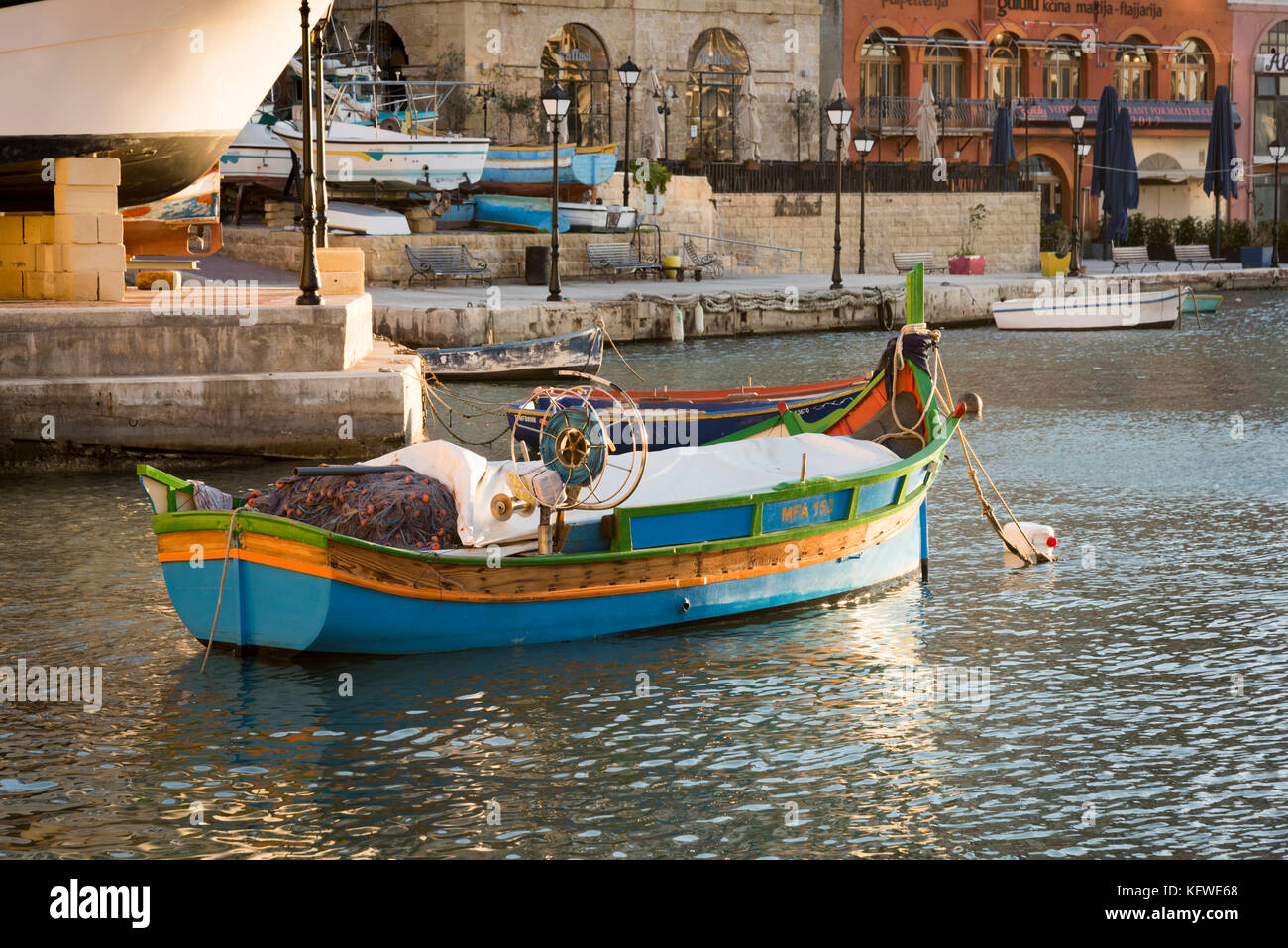 Un tradizionale, dipinto luminosamente, Maltese barca da pesca o luzzu ormeggiata in St Julians Bay Malta Foto Stock