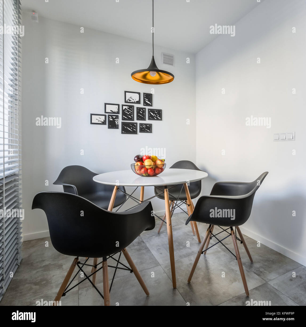 Casa bianca di interno con lampada, moderno tavolo rotondo e sedie nere Foto Stock