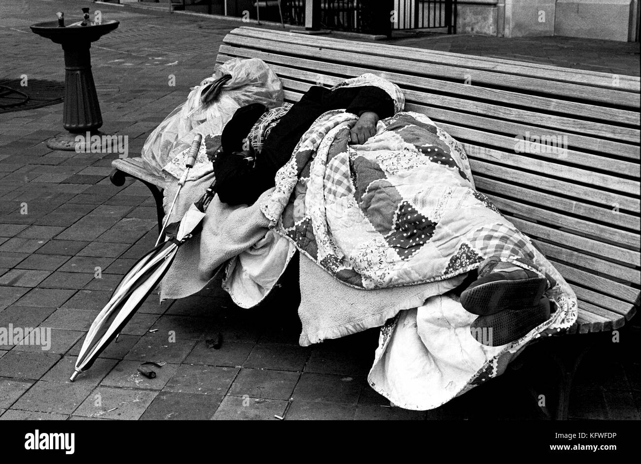Uomo dorme grezzo su un banco di lavoro per le strade LA, STATI UNITI D'AMERICA Foto Stock