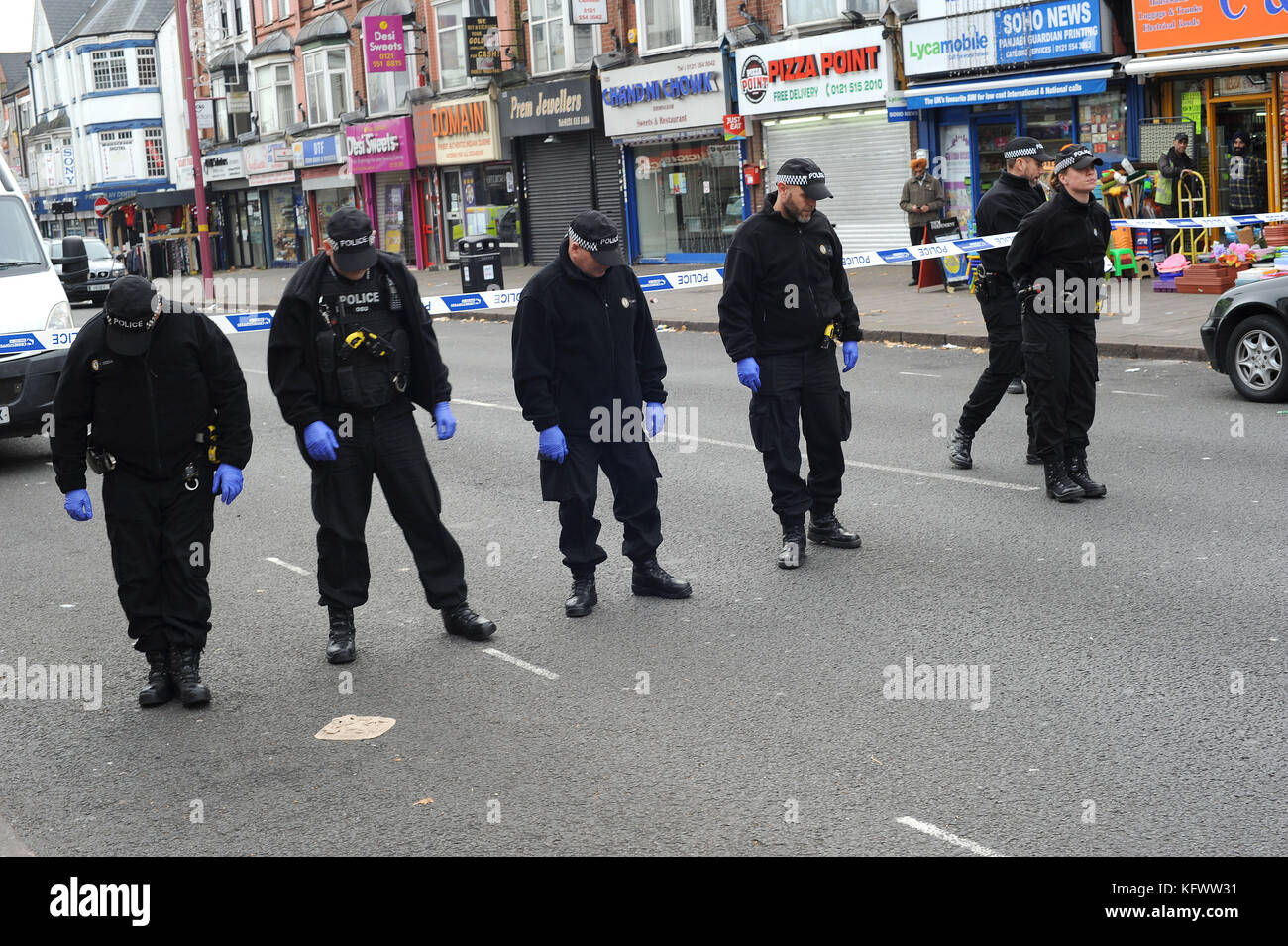 Birmingham, Regno Unito. 1 nov, 2017. ufficiali da west midlands police team forensic, cerca la strada al di fuori della scena di un incidente che coinvolga gli spari, in prossimità delle spezie takeaway ristorante sulla strada di Soho in handsworth. west midlands servizio ambulanza erano chiamati fuori la sera precedente a circa 10.50 pm, rispondendo ad un assalto riportati al di fuori dei pasti da asporto. parte di Soho road è stato chiuso per oltre dodici ore mentre la polizia effettuare una seria di ricerche al di fuori del ristorante. Credito: Kevin hayes/alamy live news Foto Stock