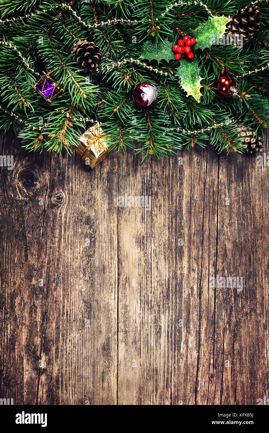 Rami dell'abete natalizio con giocattoli su vecchio tavolo di legno Foto Stock