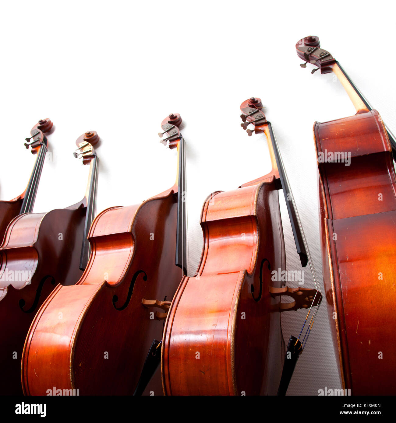 Fila di contrabbassi contro una parete sulla foto quadrata Foto Stock