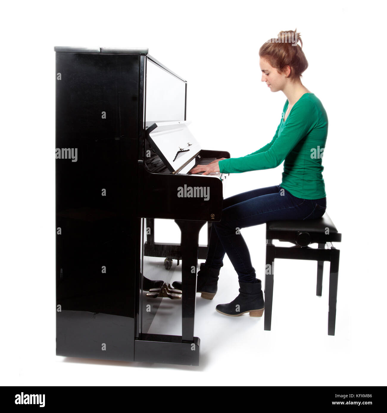 Ragazza adolescente suona il pianoforte in camicia verde Foto Stock
