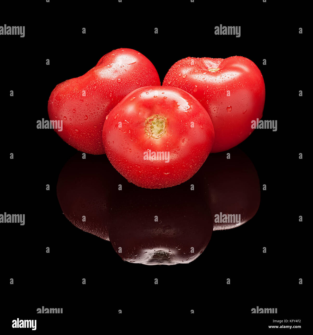 3 pomodori rossi grandi isolato nero su sfondo lucido con una vera riflessione. vista laterale Foto Stock