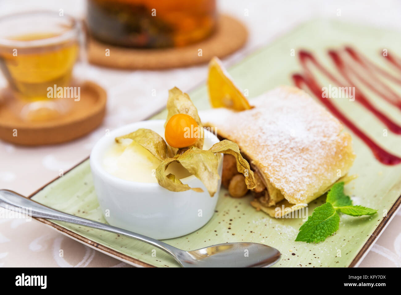 Strudel di mele fatto in casa con zucchero in polvere, gelato alla vaniglia e foglie di menta Foto Stock