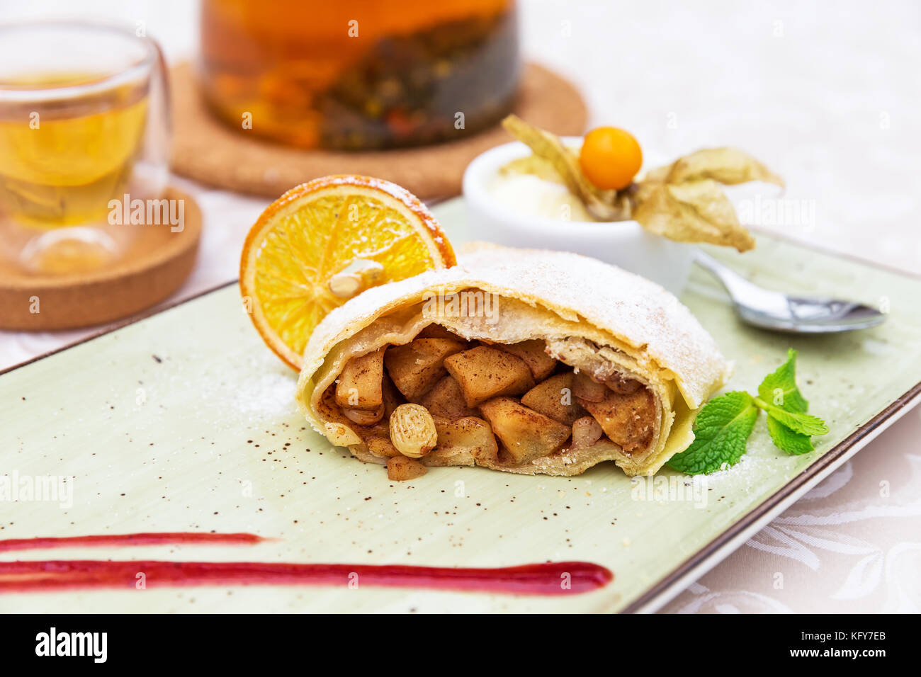 Strudel di mele fatto in casa con zucchero in polvere, gelato alla vaniglia e foglie di menta Foto Stock