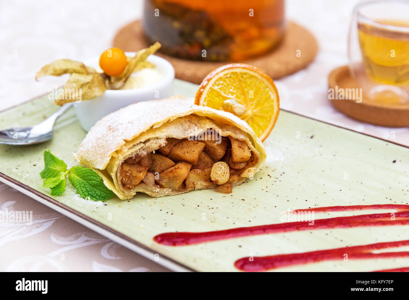 Strudel di mele fatto in casa con zucchero in polvere, gelato alla vaniglia e foglie di menta Foto Stock