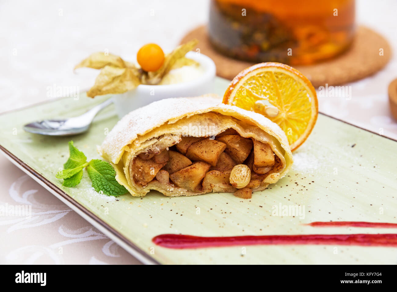 Strudel di mele fatto in casa con zucchero in polvere, gelato alla vaniglia e foglie di menta Foto Stock