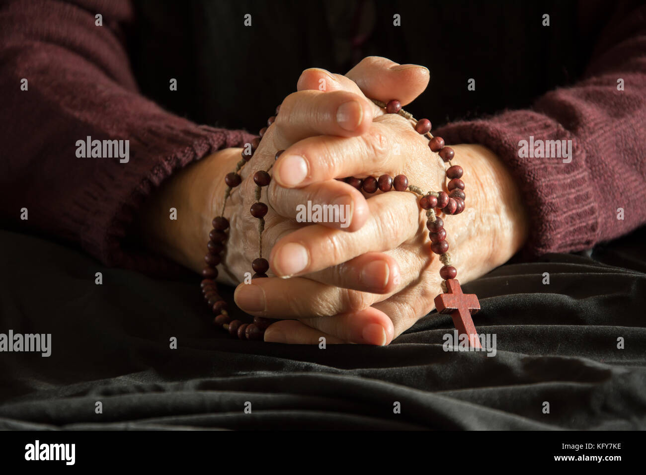 Vecchia donna con le mani un rosario Foto Stock