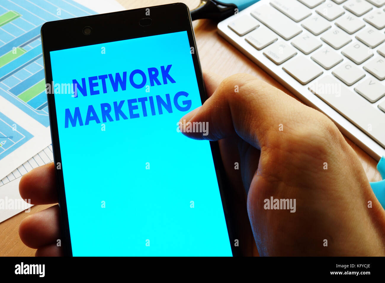 Mano azienda smartphone con parole di network marketing. Foto Stock