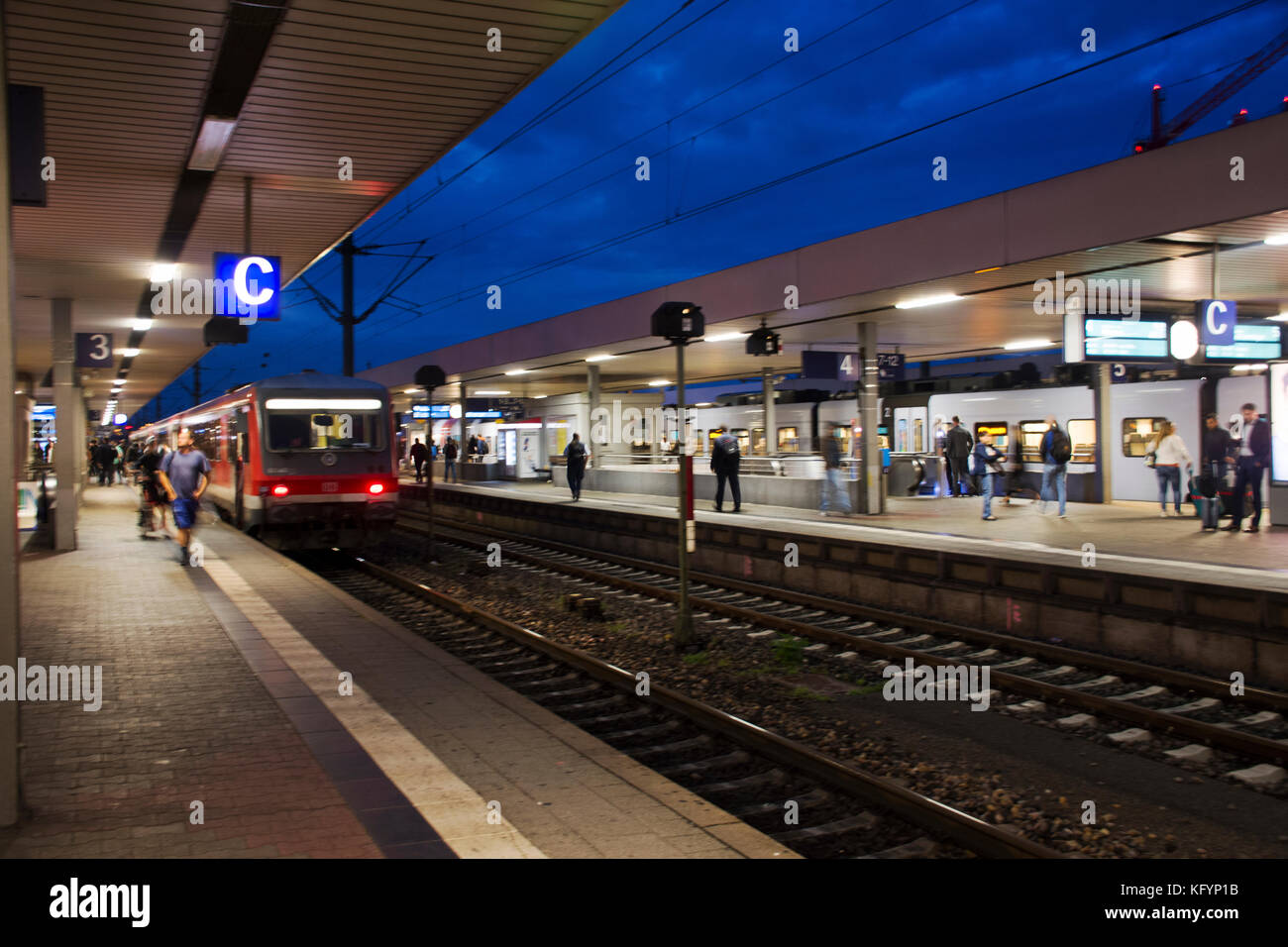 La gente a piedi e attendere con la marcia di un treno in terminale per inviare e ricevere i passeggeri a Mannheim hauptbahnhof stazione ferroviaria il 5 settembre 2017 in m Foto Stock