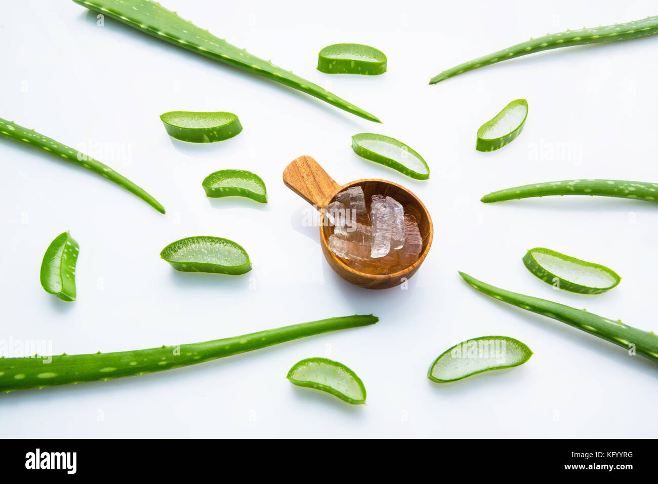 Aloe foglie fresche con aloe vera gel su misura in legno cucchiaio. isolato su bianco Foto Stock