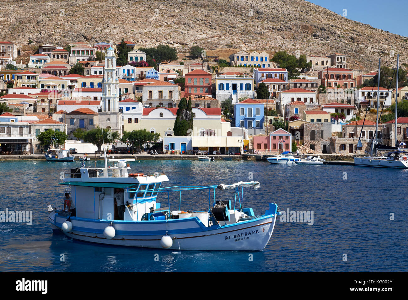 Barca da pesca in legno che lascia il porto di Nimborió, la città principale dell'isola greca di Chálki Foto Stock