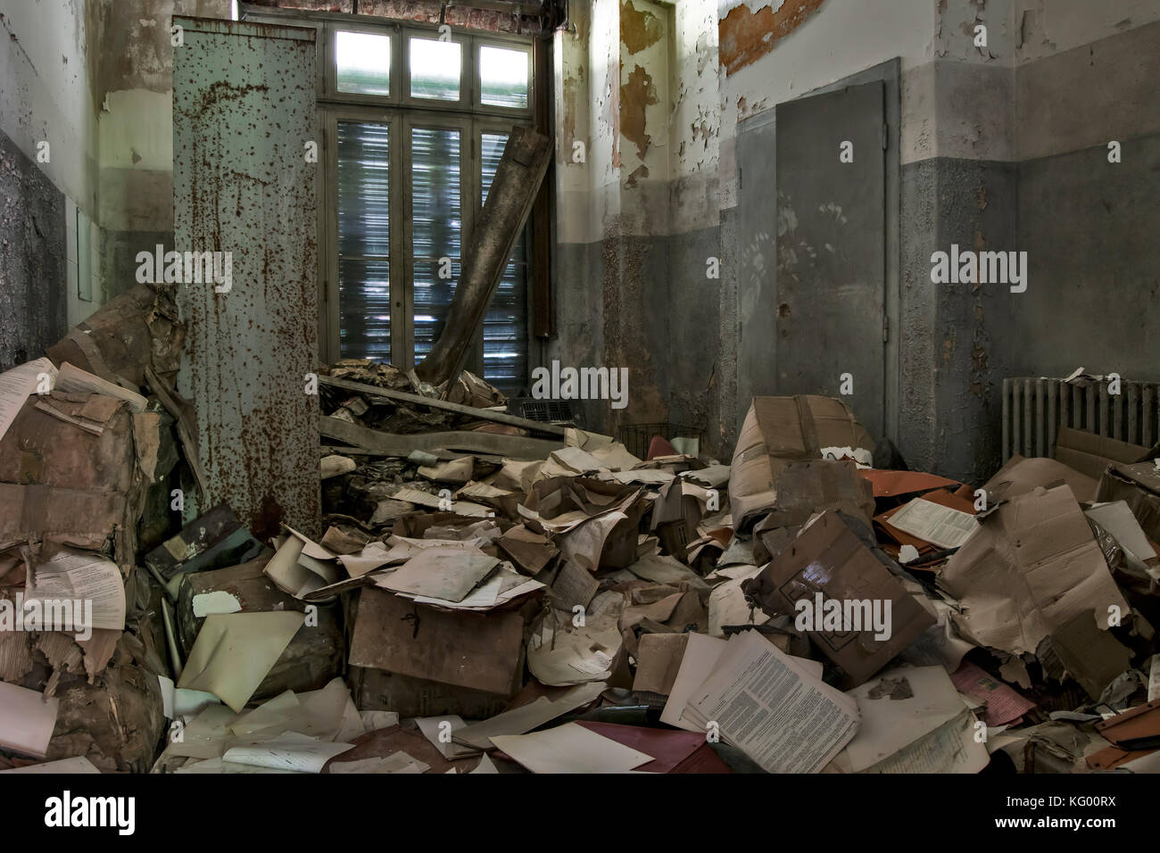 Una stanza piena di documenti sparsi sul pavimento di una stanza di un manicomio abbandonato Foto Stock