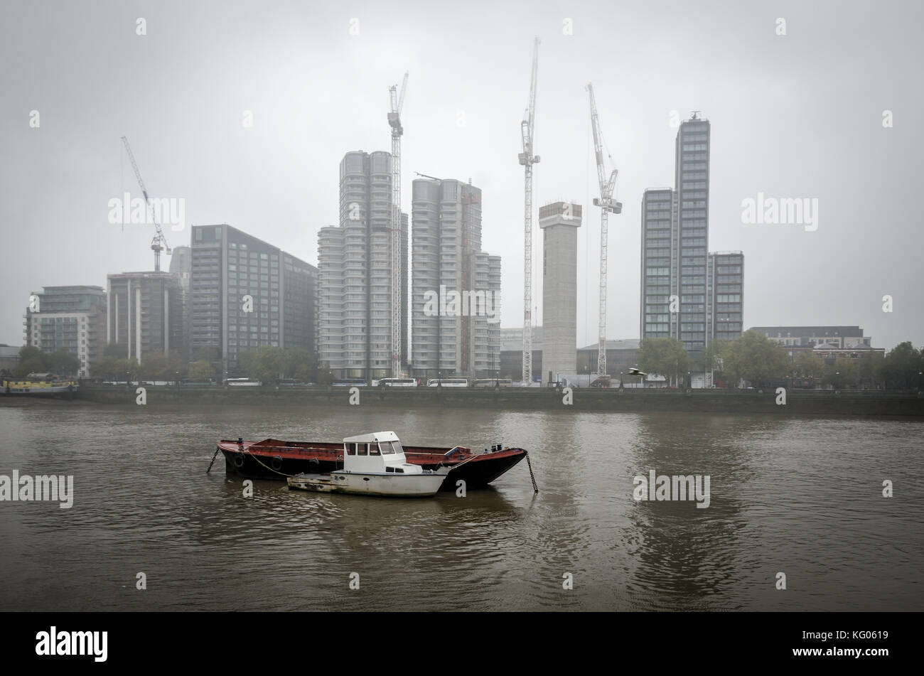 Londen, Regno Unito, 26 oktober 2017: Misty River, barca e costruire nel Tamigi. gru sono la costruzione di altri edifici. Foto Stock