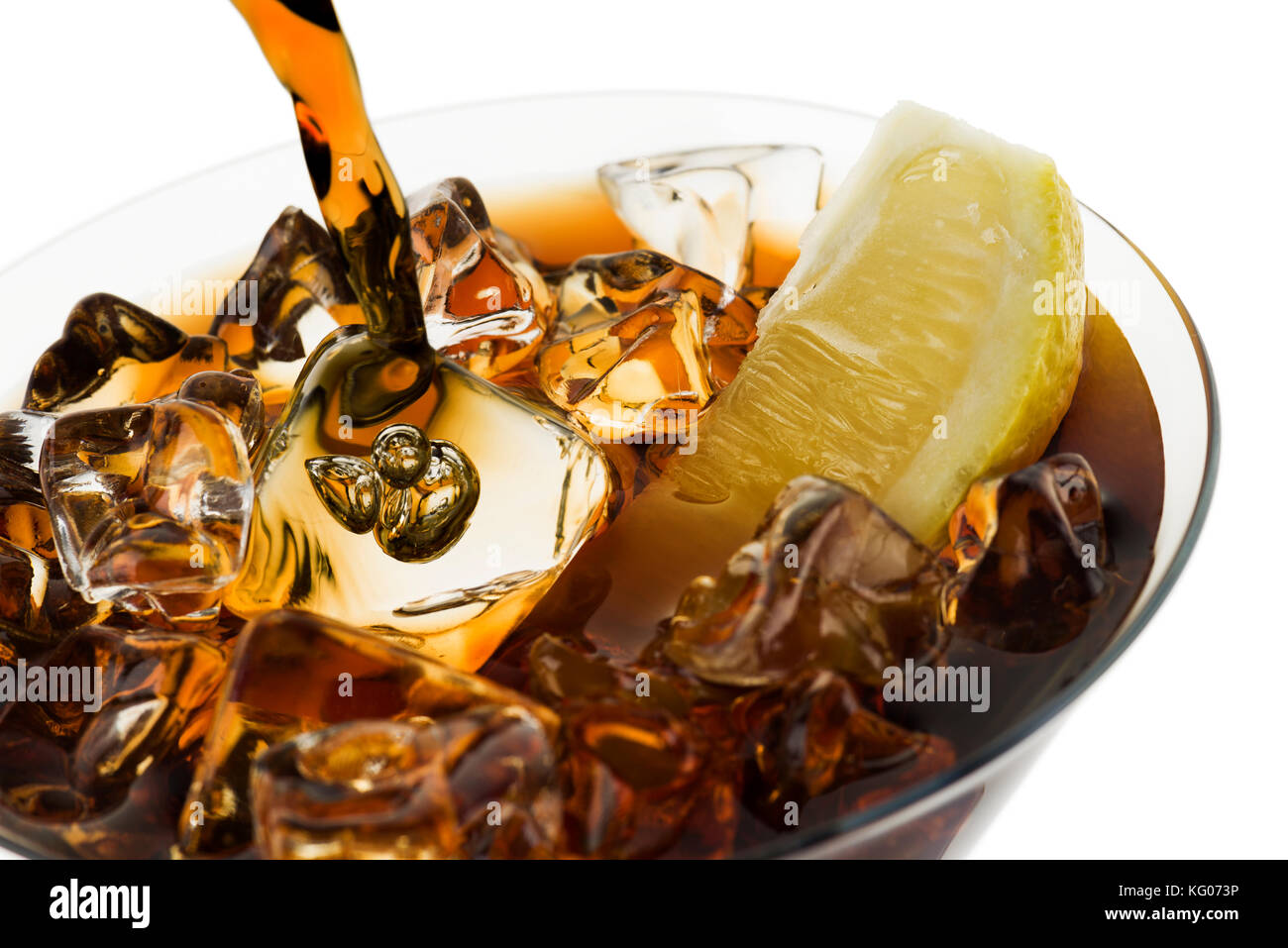 Versando cola in vetro con cubetti di ghiaccio e la fetta di limone, su sfondo bianco Foto Stock