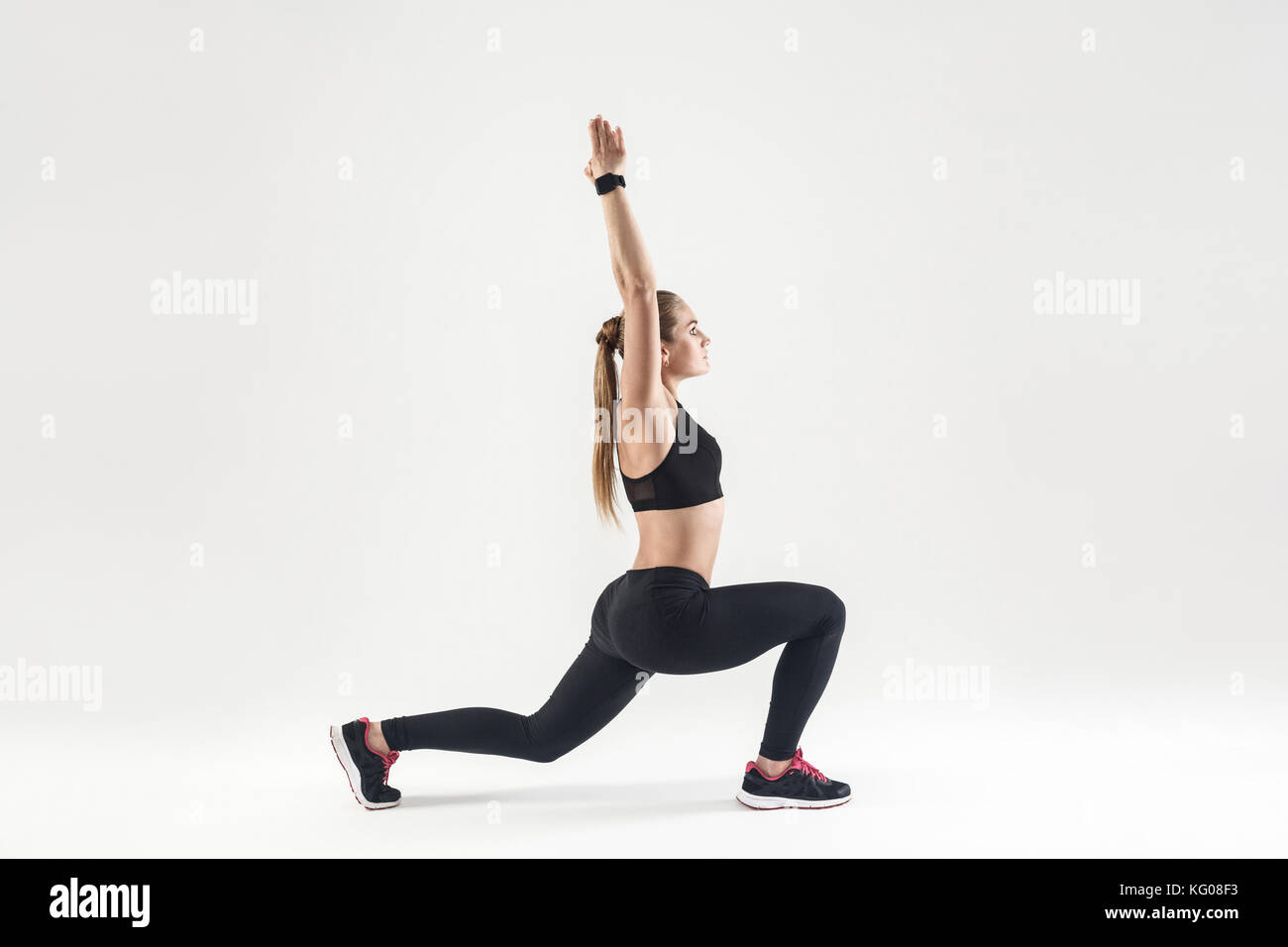 Giovane donna adulta facendo pilates. profilo, vista laterale. studio shot, sfondo grigio Foto Stock