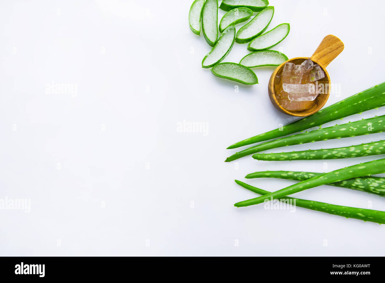 Aloe foglie fresche con aloe vera gel su misura in legno cucchiaio. isolato su bianco Foto Stock