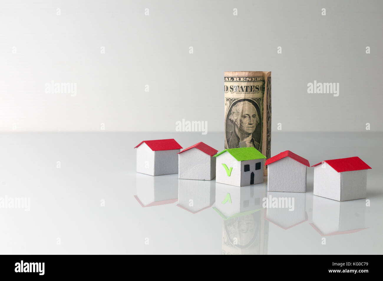 Concetto di ipoteca: cinque casa di carta e un dollaro Foto Stock