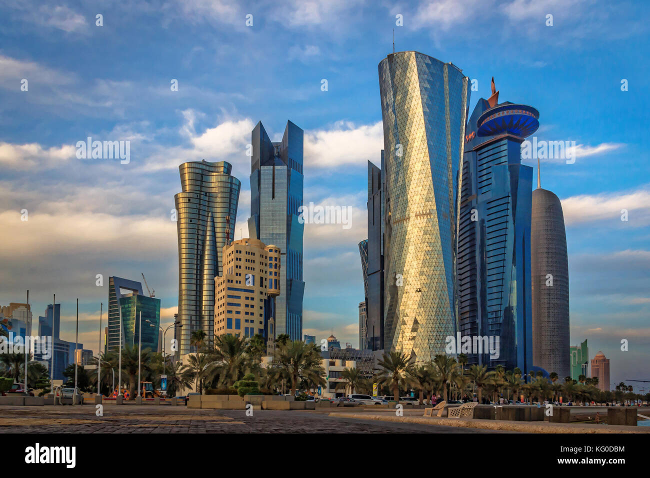 Doha in Qatar skyline di luce diurna che mostra i moderni grattacieli , auto, alberi, nuvole e street. Foto Stock