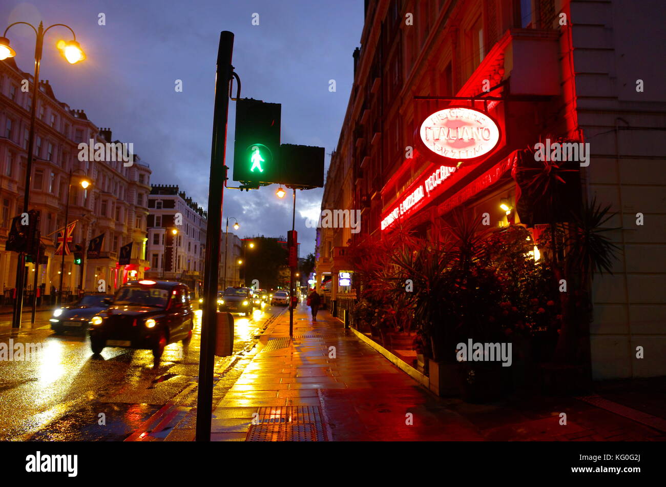 Tempo di notte tempo umido street scene in Kensington, Londra, Inghilterra Foto Stock