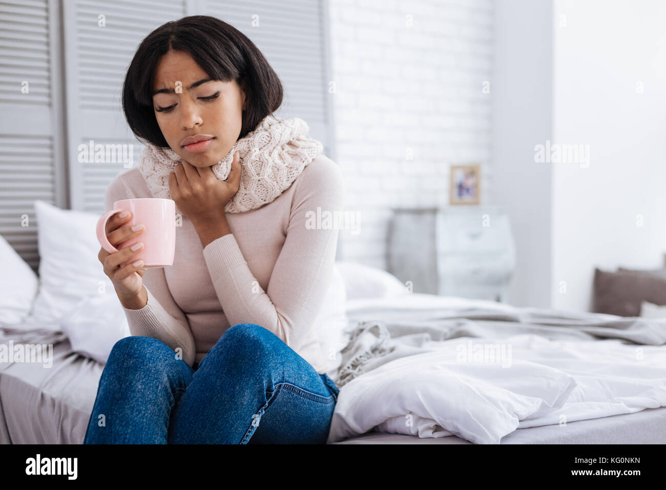 Infelice giovane donna malata avente un mal di gola Foto Stock