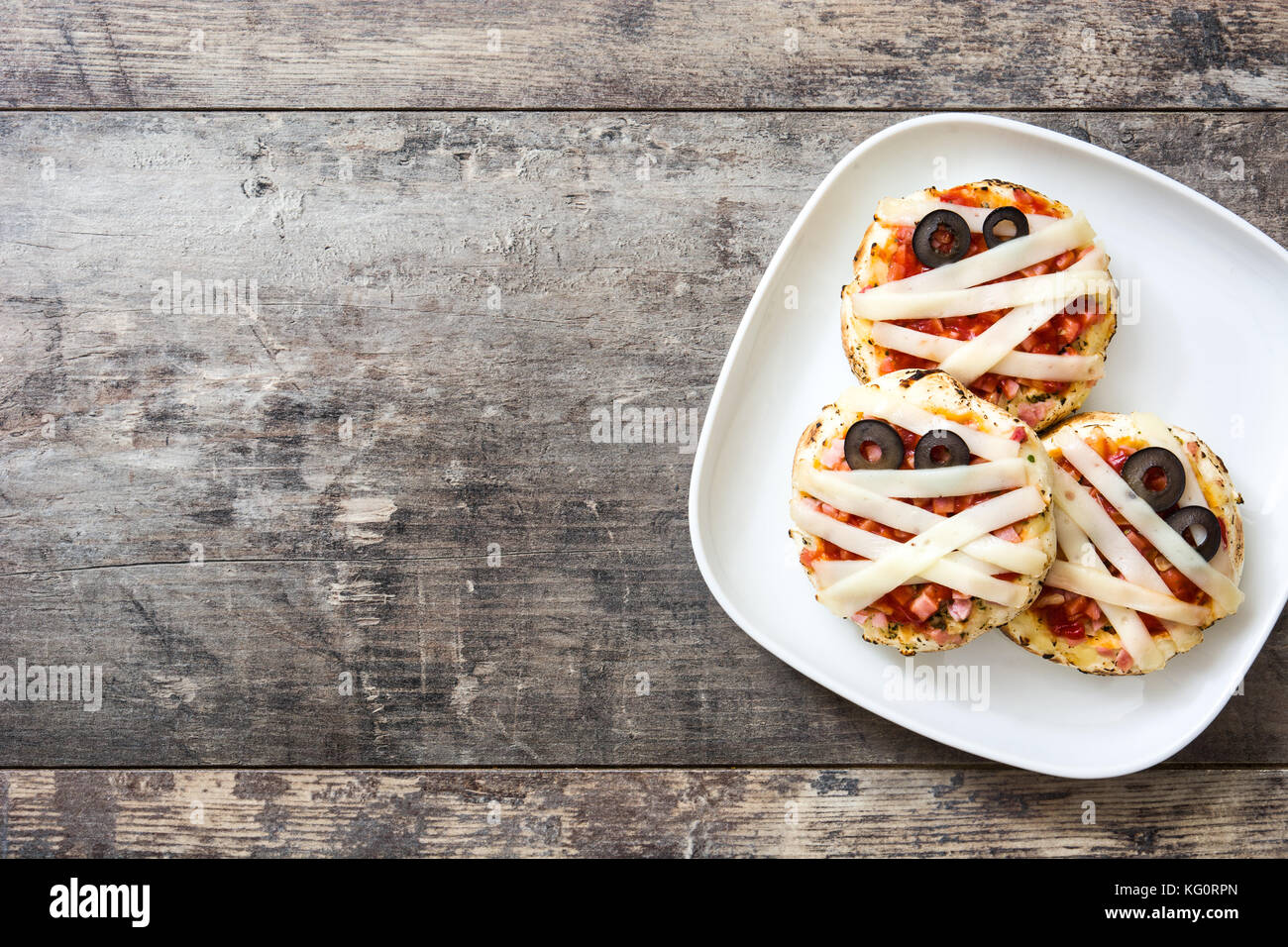 Mummie di Halloween mini pizza sul tavolo di legno. Foto Stock