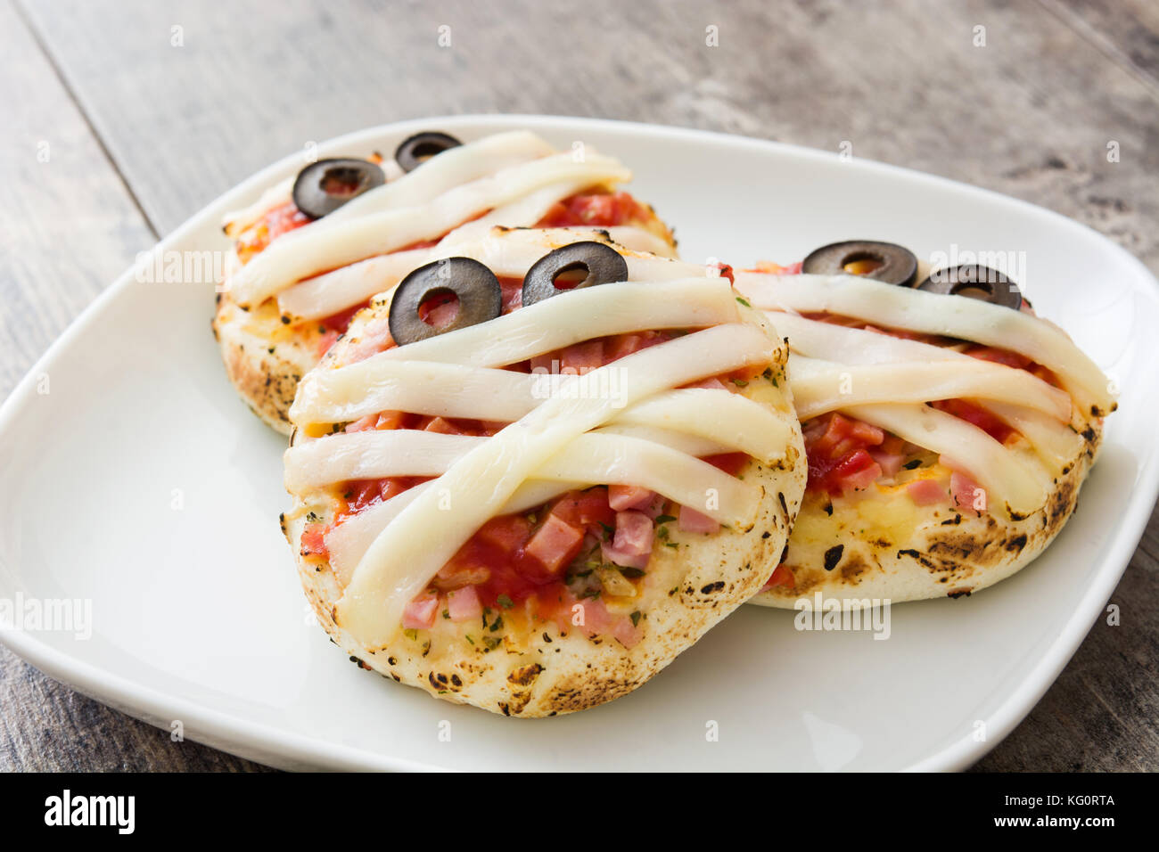 Mummie di Halloween mini pizza sul tavolo di legno. Foto Stock