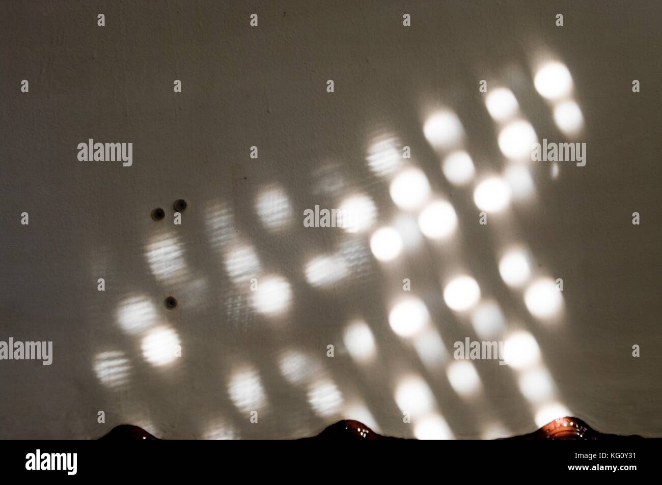 Punti di luce riflessa in una parete Foto Stock