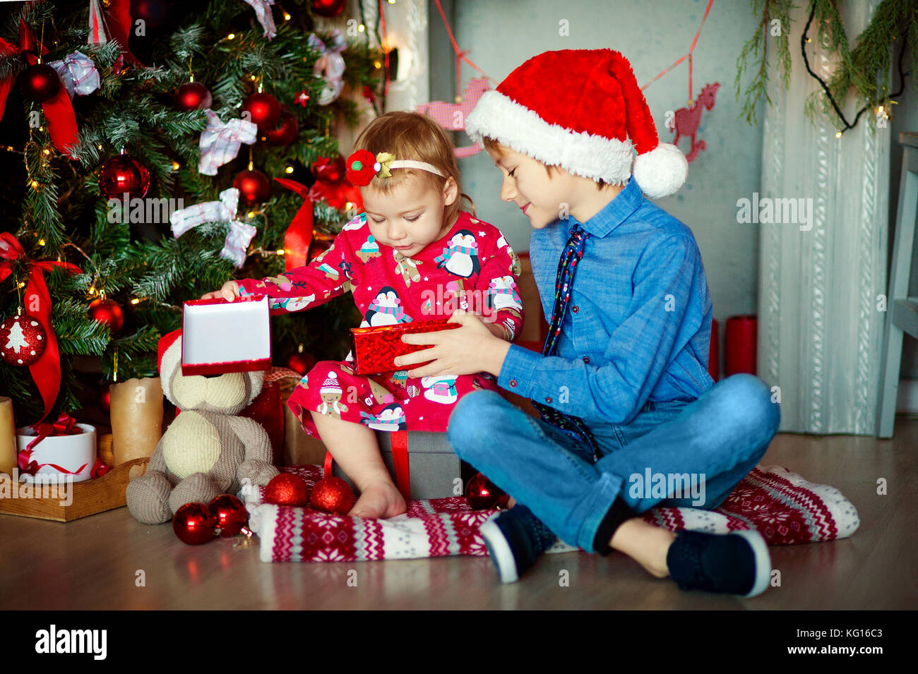 Famiglia Alla Vigilia Di Natale A Camino Bambini Apertura Xmas Presenta I Bambini Al Di Sotto Dei Albero Di Natale Con Confezioni Regalo Decorate Soggiorno Con Un Tradizionale Camino Accogliente Caldo Inverno