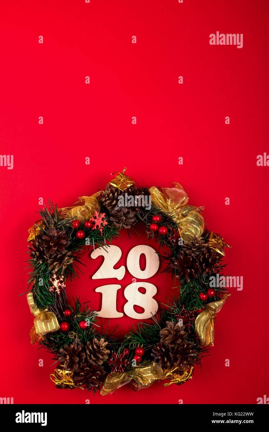 Ghirlanda di Natale, composizione vacanze 2018 su uno sfondo di colore rosso. vista superiore Foto Stock