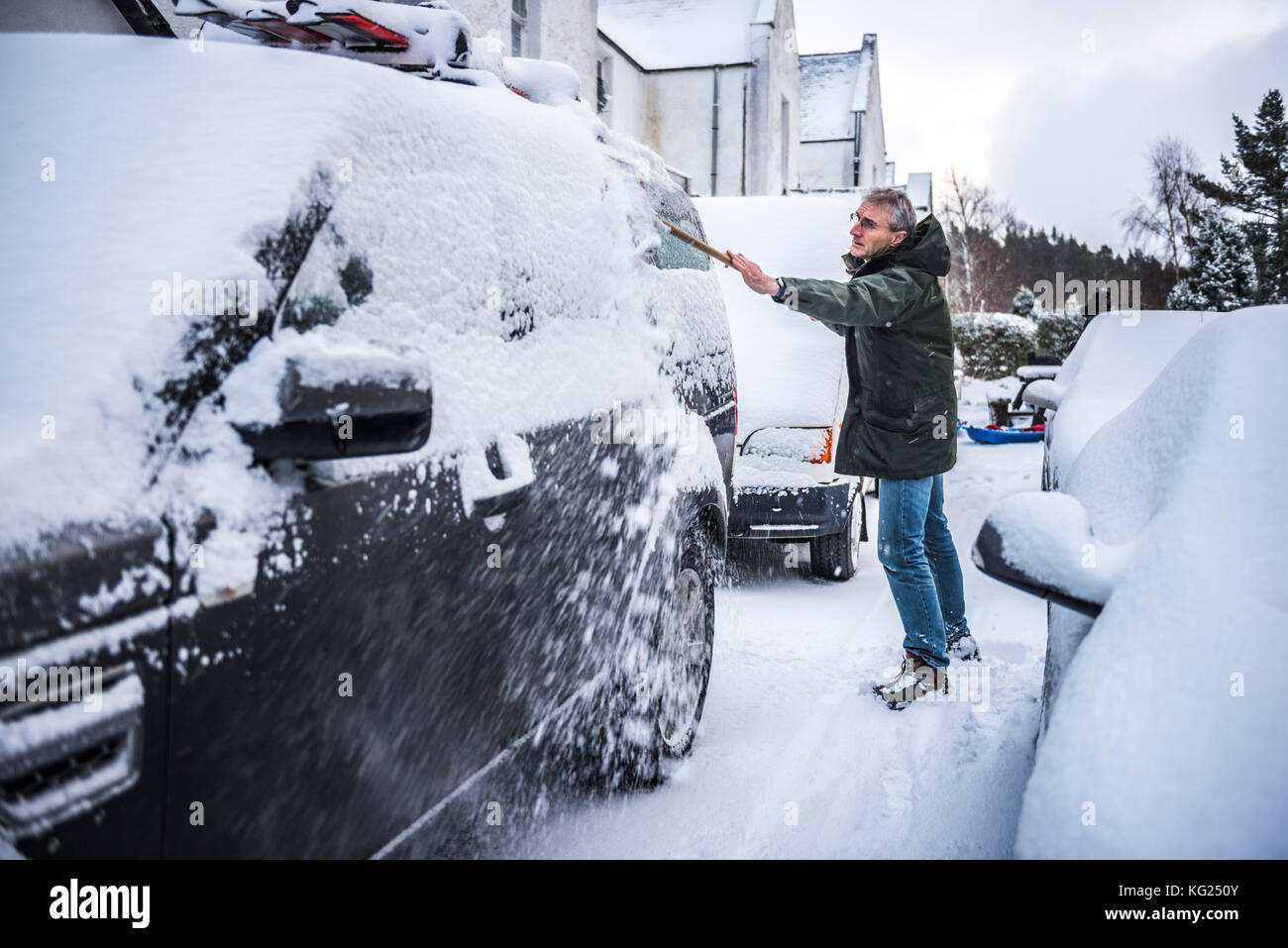 Rimozione di neve da un auto, Cairngorms National Park, Scotland, Regno Unito, Europa Foto Stock