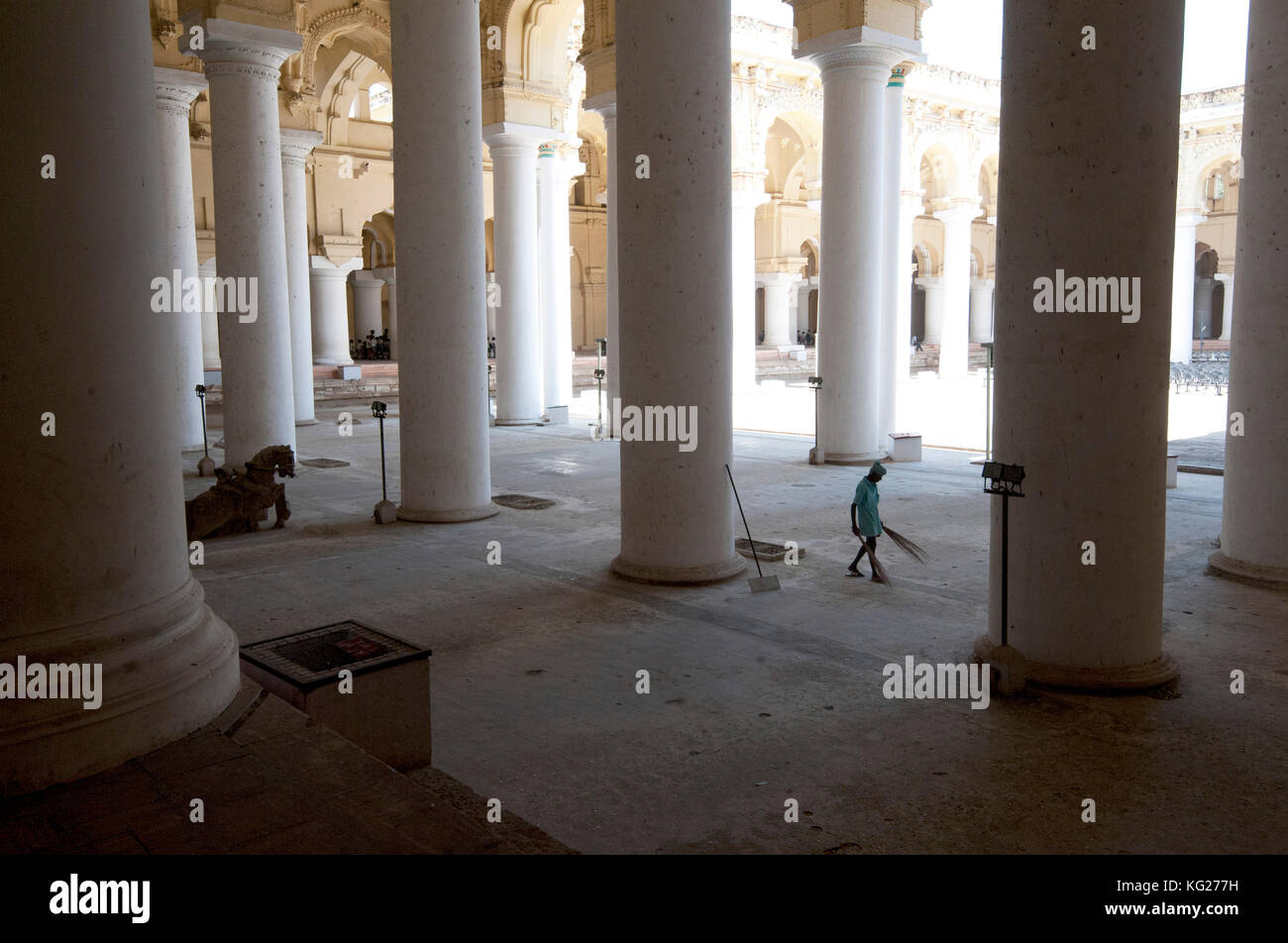 Pulitore con palme che spazza la sala dei mille pilastri all'interno del XVII secolo Thirumalai Nayakkar Mahal, Madurai, Tamil Nadu, India, Asia Foto Stock