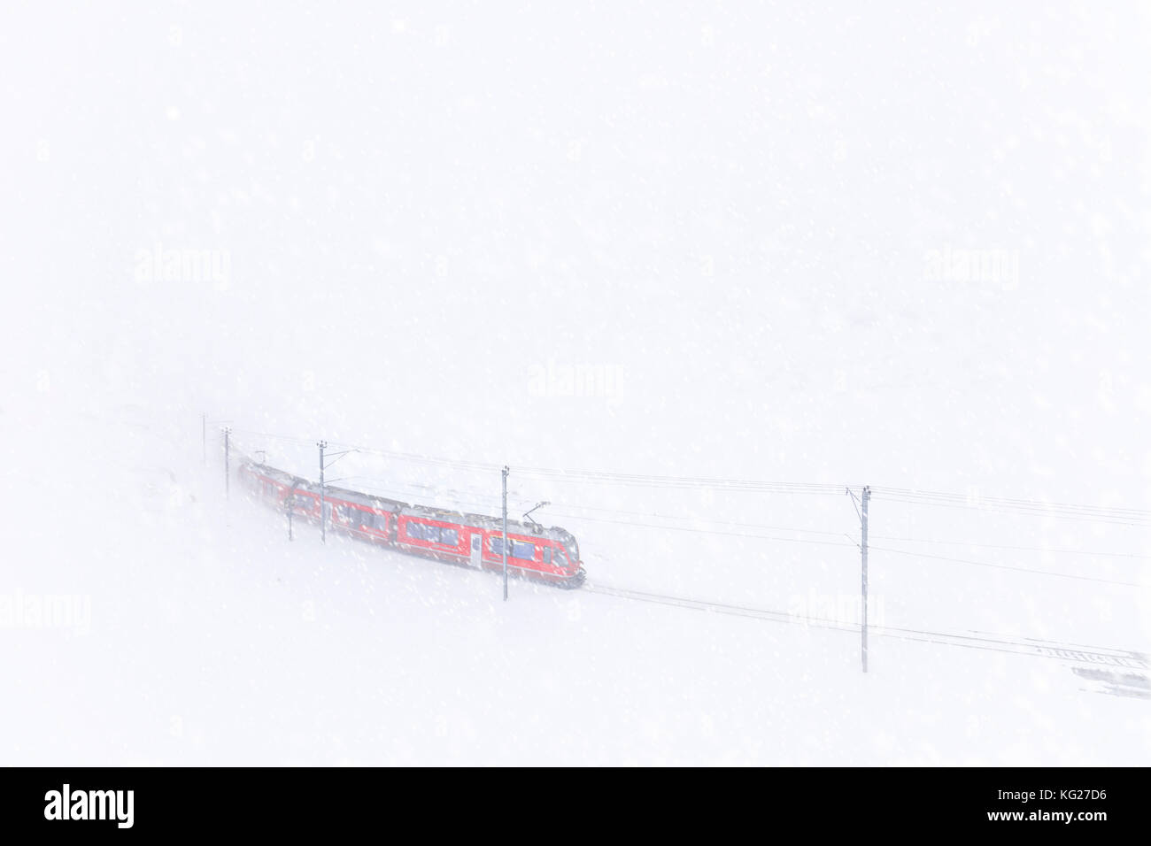 Bernina Express al Passo Bernina durante una tempesta di neve, in Engadina, nel canton Grigioni, Svizzera, Europa Foto Stock