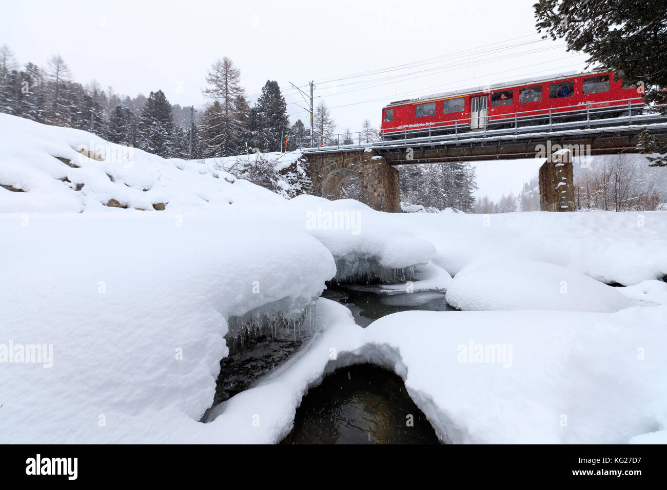 Il Bernina Express nel paesaggio innevato di Morteratsch Engadin del cantone dei Grigioni, Svizzera, Europa Foto Stock