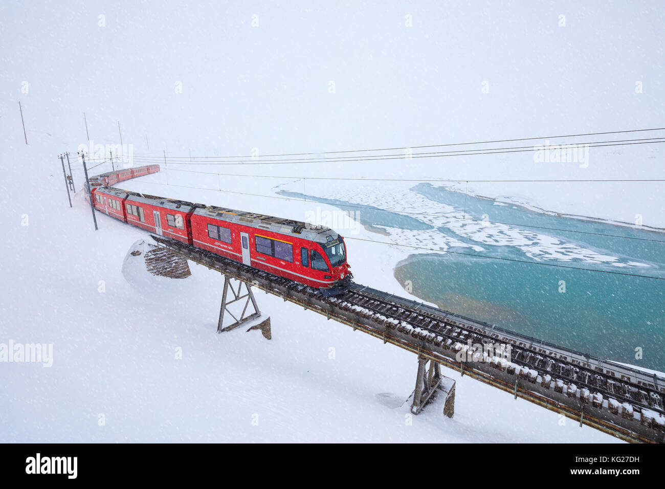 Bernina Express al Passo Bernina sotto una nevicata, Engadina nel cantone dei Grigioni, Svizzera, Europa Foto Stock