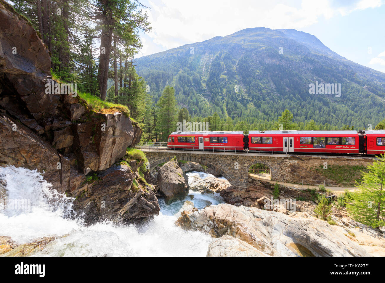 Bernina Express accanto al torrente alpino, morteratsch engadin del cantone dei Grigioni, Svizzera, Europa Foto Stock