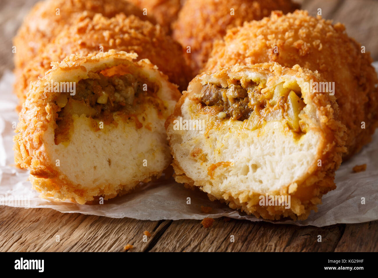 Taglio giapponese kare-pan nel pangrattato macro sul tavolo orizzontale. Foto Stock