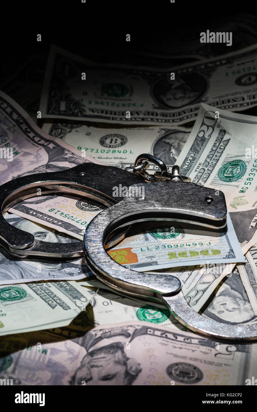 Una coppia di aprire manette su una pila di dollari americani con una elevata profondità di campo. Foto Stock