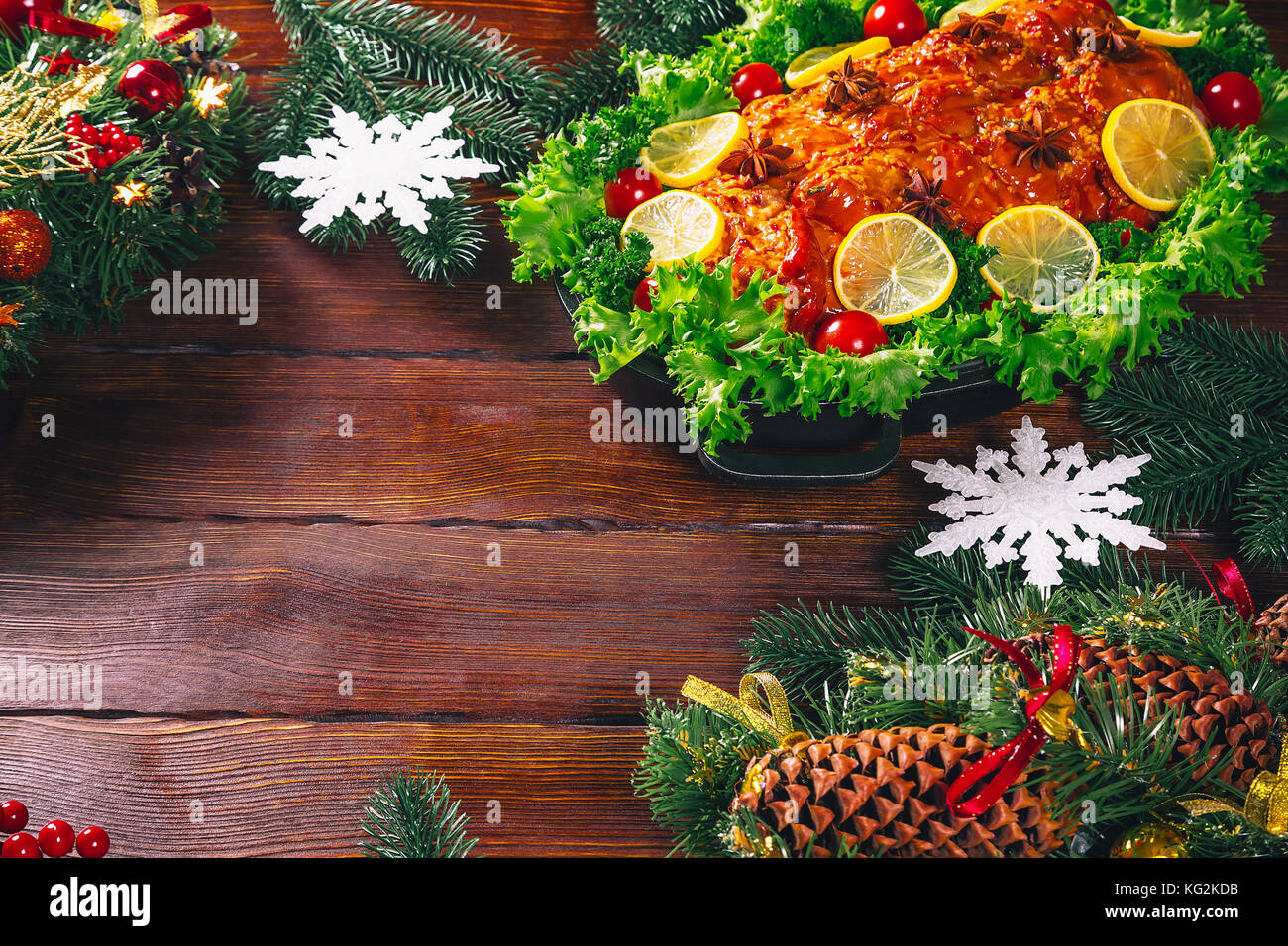 Tabella di ringraziamento servita con carni cotte, decorata con luminose decorazioni natalizie e candele. Cena di Natale con arrosti di carne di maiale. Il concetto o Foto Stock