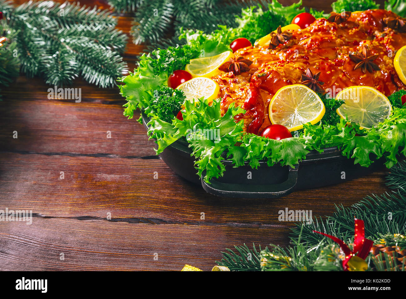 Tabella di ringraziamento servita con carni cotte, decorata con luminose decorazioni natalizie e candele. Cena di Natale con arrosti di carne di maiale. Il concetto o Foto Stock