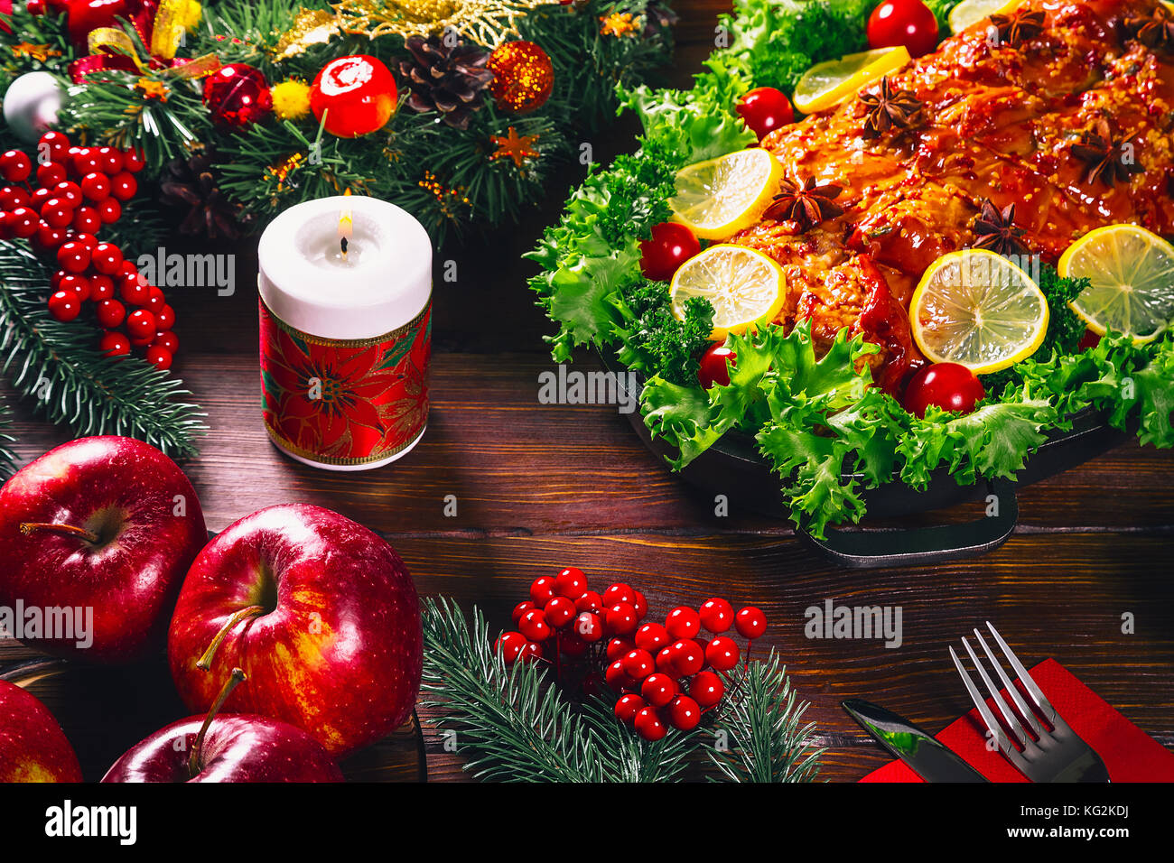 Tabella di ringraziamento servita con carni cotte, decorata con luminose decorazioni natalizie e candele. Cena di Natale con arrosti di carne di maiale. Il concetto o Foto Stock