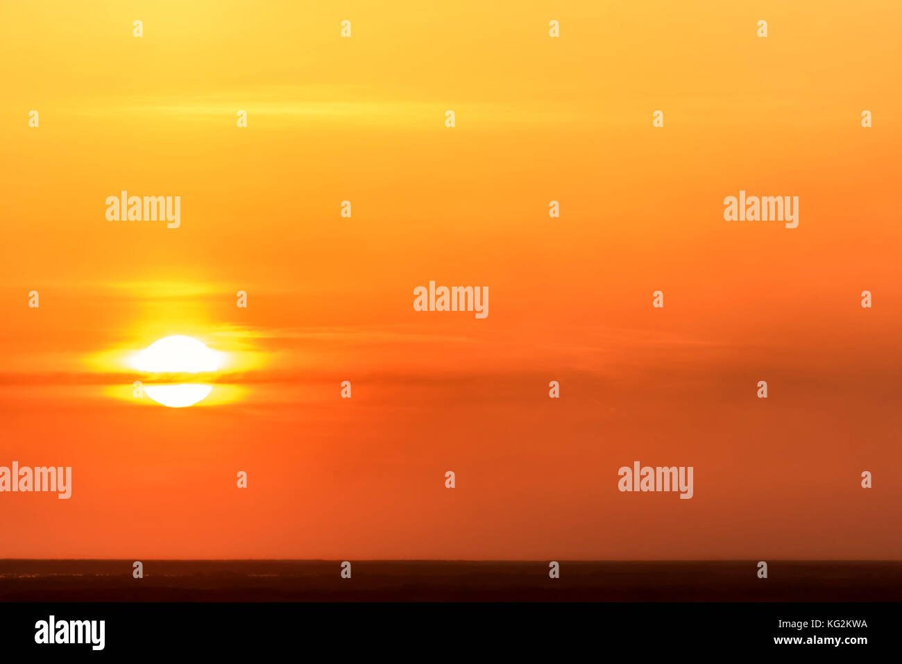 Colorato sfondo astratto con sole e nuvole contro lo sfondo di un ardente cielo arancione al tramonto Foto Stock