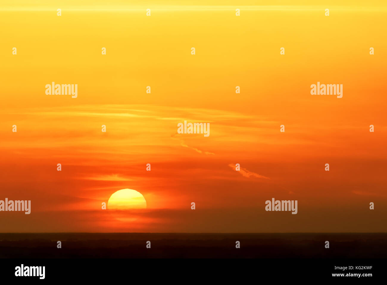 Colorato sfondo astratto con sole e nuvole contro lo sfondo di un ardente cielo arancione al tramonto Foto Stock