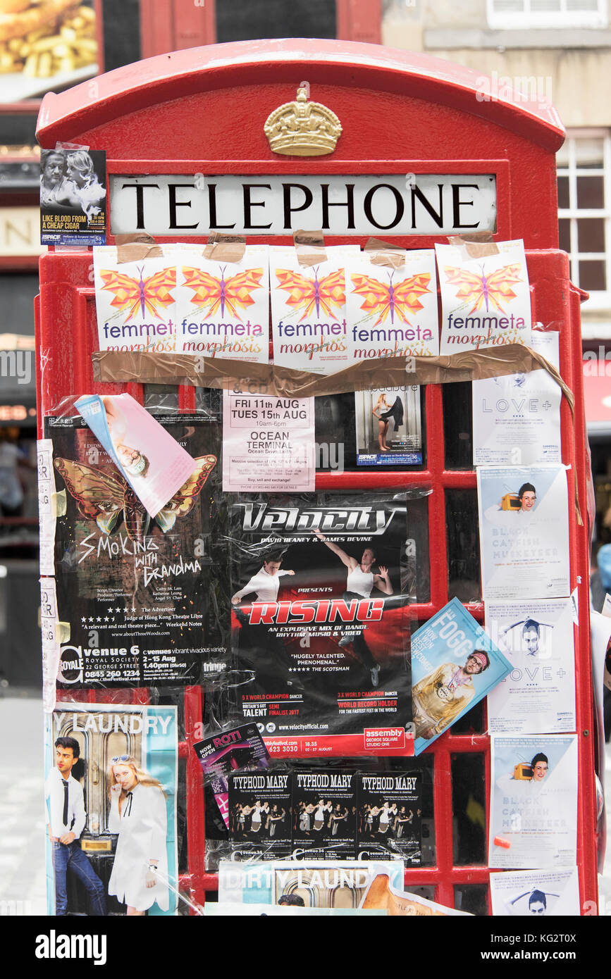 Un telefono rosso casella sul Royal Mile di Edimburgo coperto di volantini promozione Festival Fringe mostra. Foto Stock