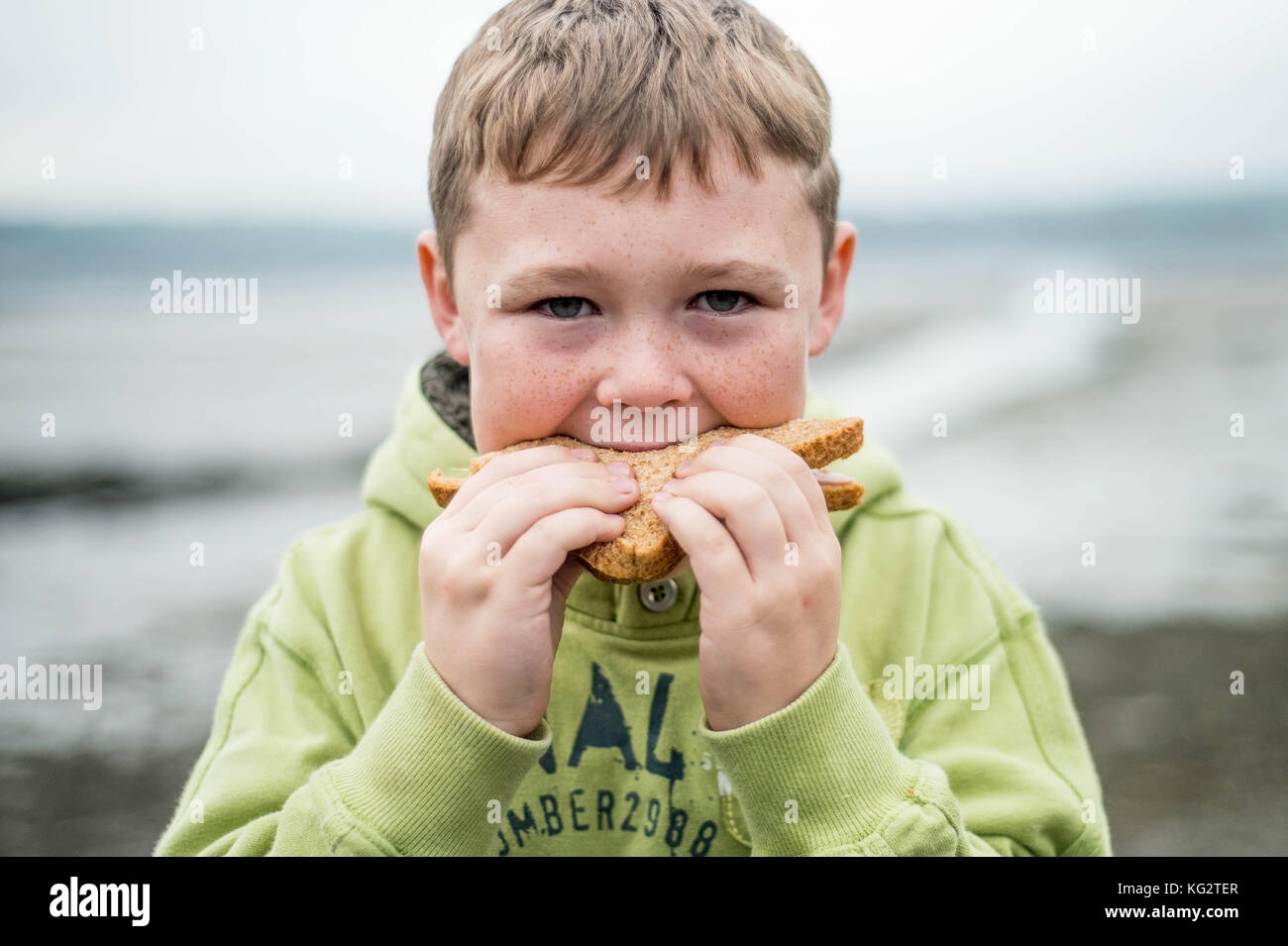 Giovedì 02 Novembre 2017 Una giovane 8,9,10 anno vecchio ragazzo mangia un sano panino al di fuori Foto Stock