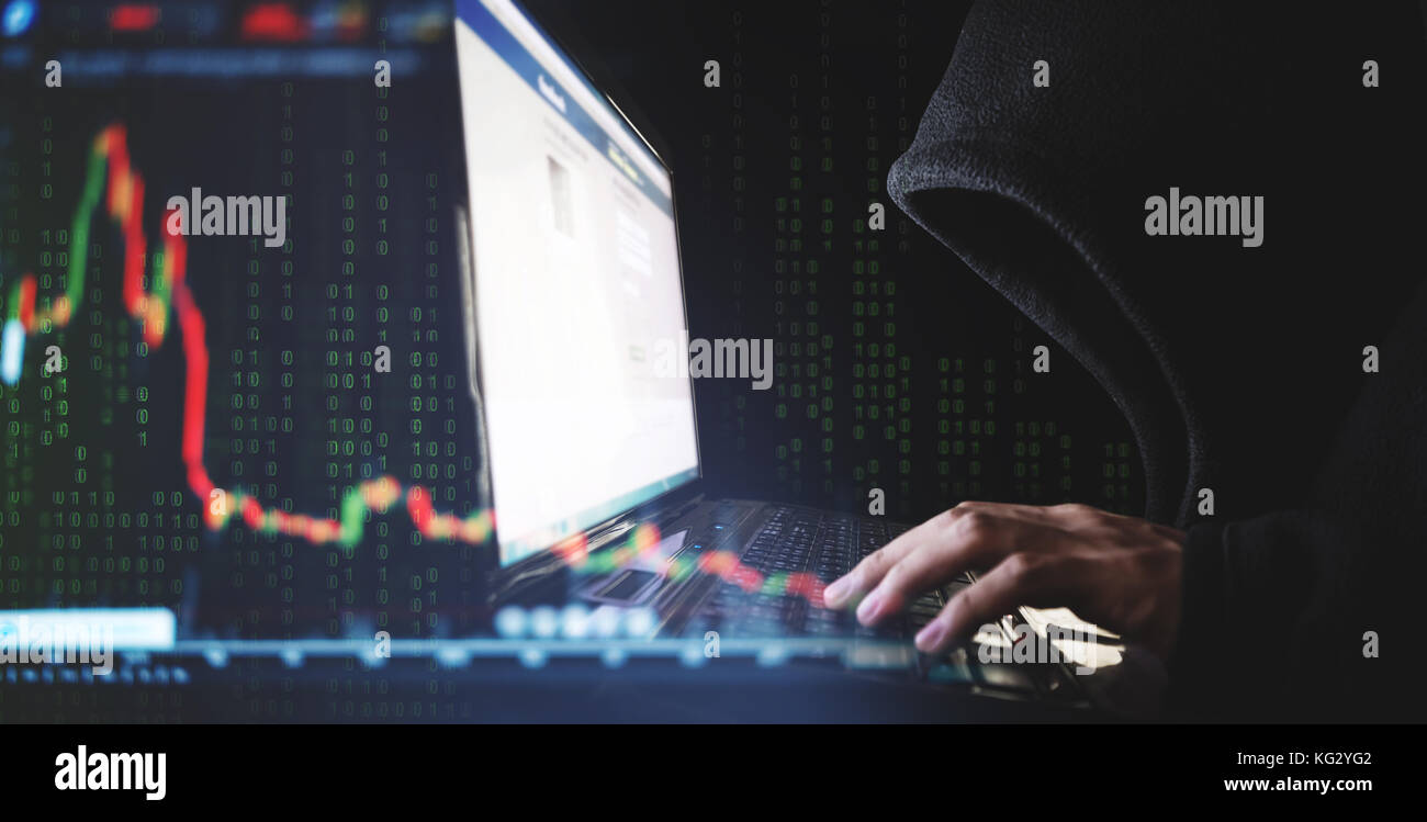 La criminalità su internet e speculare stock concetti, hacker che lavora sul computer portatile con stock verso il basso sfondo grafico Foto Stock