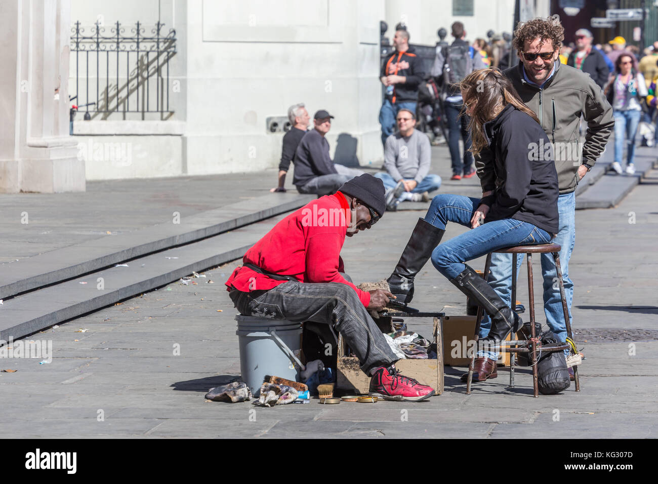 Shoeshiner o lucidatrice uomo pulisce gli stivali da donna a Jackson Square, quartiere francese di New Orleans, Louisiana Foto Stock