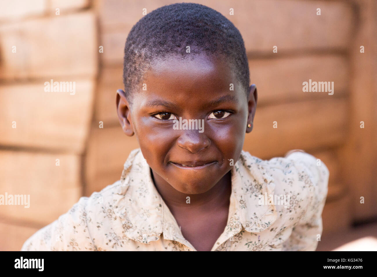 Un sorridente ragazza di fronte di una capanna di legno. Foto Stock