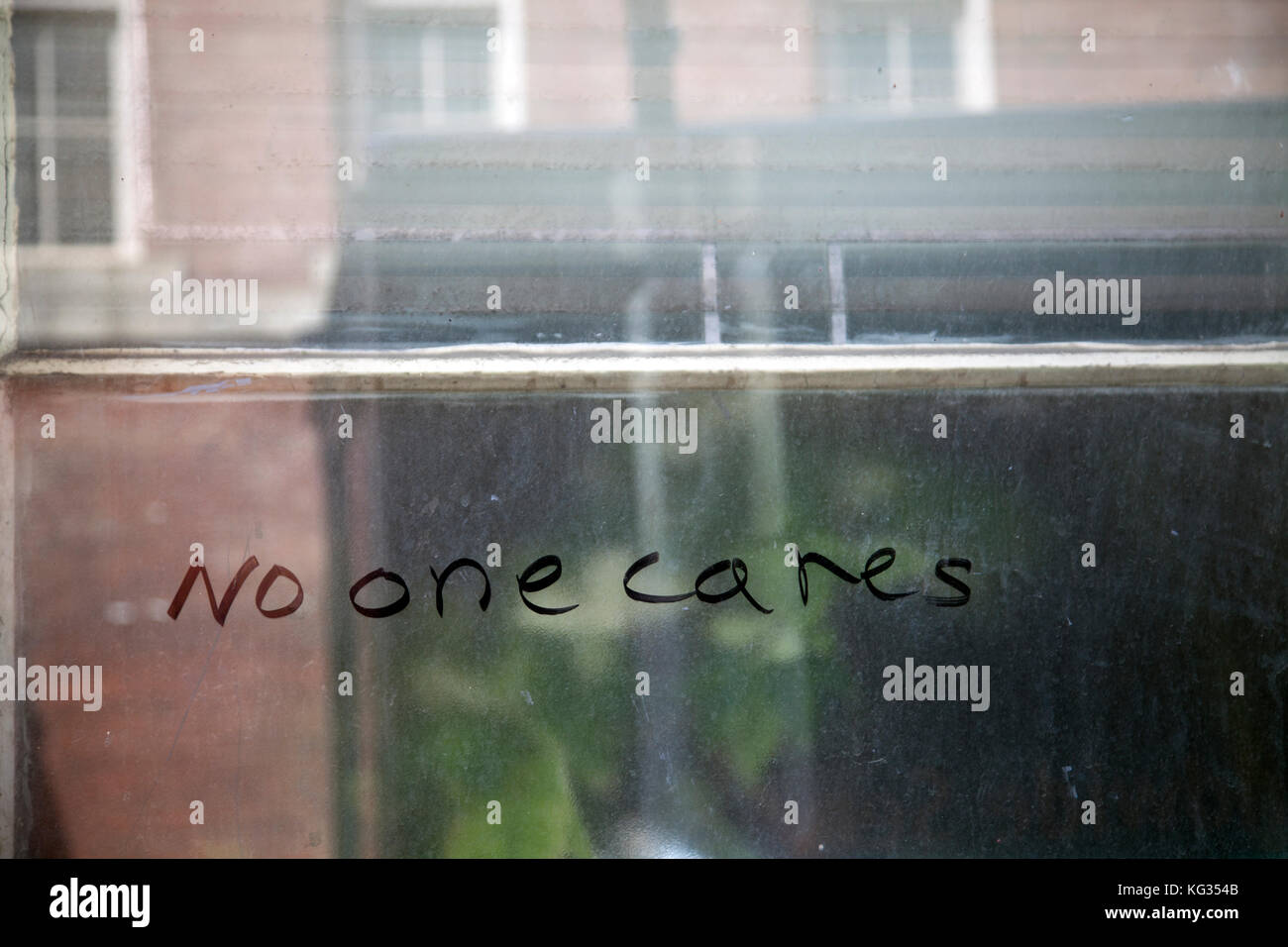 Nessuno si prende cura scritto sul vetro sporco finestra - Philadelphia Foto Stock